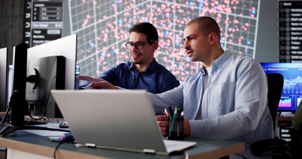 Business professional using mobile phone for MFA login on laptop.